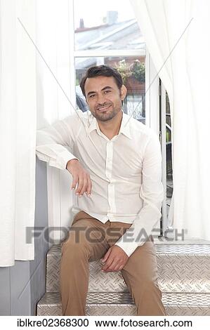 Smiling man sitting at a balcony door with curtains View Large Photo Image Stock Image - Smiling man sitting at a balcony door with curtains. Fotosearch