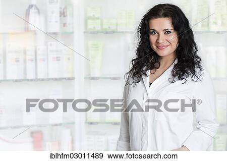 Stock Photo - Smiling pharmacist standing in front of medicine shelves. Fotosearch
