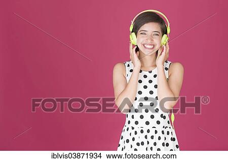 Smiling woman listening to music on headphones View Large Photo Image Picture - Smiling woman listening to music on headphones. Fotosearch