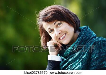 Stock Image - "Smiling woman outdoors, portrait". Fotosearch
