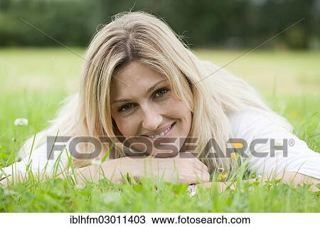 "Smiling woman relaxing on her stomach in the grass, Schaumburg, Stadthagen, Lower Saxony, Germany, Europe" View Large Photo Image Stock Image - "Smiling woman relaxing on her stomach in the grass, Schaumburg, Stadthagen, Lower Saxony, Germany, Europe". Fotosearch