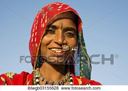 Stock Photo - "Smiling young Indian woman with a colourful scarf and jewellery, portrait, Pushkar, Rajasthan, India, Asia". Fotosearch