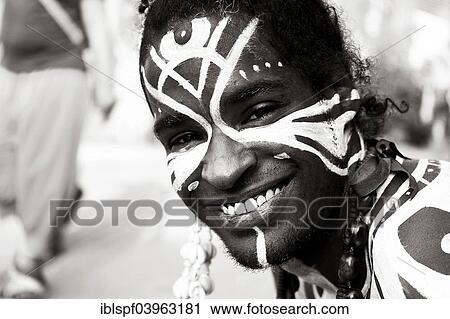 Stock Image - "Smiling young man with Polynesian war paint, portrait, Berlin, Germany, Europe". Fotosearch