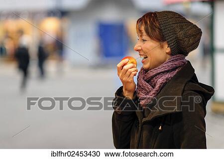 "Smiling young woman eating an apple, Grevenbroich, North Rhine-Westphalia, Germany, Europe" View Large Photo Image Stock Image - "Smiling young woman eating an apple, Grevenbroich, North Rhine-Westphalia, Germany, Europe". Fotosearch