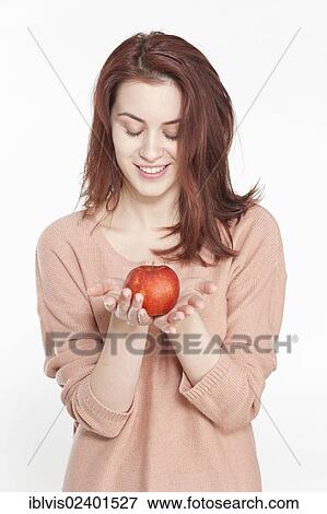 Smiling young woman holding apple View Large Photo Image Stock Photo - Smiling young woman holding apple. Fotosearch