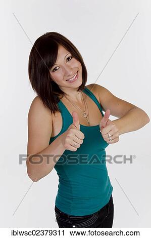 Smiling young woman making thumbs up gesture View Large Photo Image Stock Image - Smiling young woman making thumbs up gesture. Fotosearch