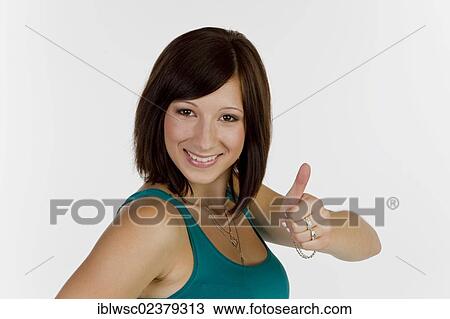 Smiling young woman making thumbs up gesture View Large Photo Image Stock Image - Smiling young woman making thumbs up gesture. Fotosearch