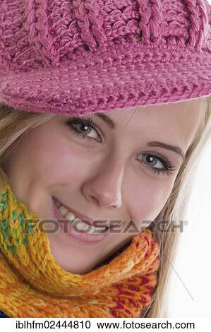 "Smiling young woman wearing a colourful scarf and a pink knit cap, portrait" View Large Photo Image Stock Image - "Smiling young woman wearing a colourful scarf and a pink knit cap, portrait". Fotosearch