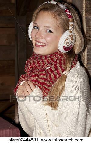 Smiling young woman wearing ear warmers and a scarf in a hiking hut View Large Photo Image Stock Image - Smiling young woman wearing ear warmers and a scarf in a hiking hut. Fotosearch