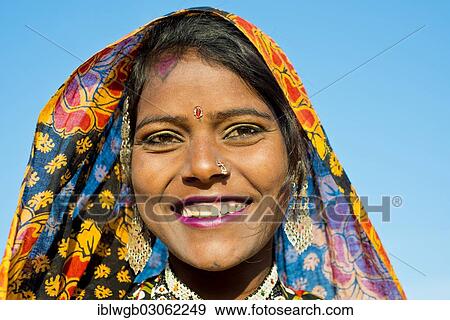 "Smiling young woman with a colourful scarf and jewellery, portrait, Kamelmarkt,, Pushkar, Rajasthan, India, Asia" View Large Photo Image Stock Photo - "Smiling young woman with a colourful scarf and jewellery, portrait, Kamelmarkt,, Pushkar, Rajasthan, India, Asia". Fotosearch