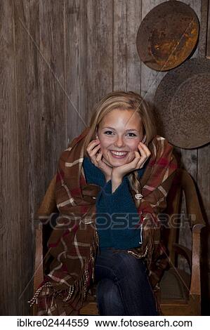 Smiling young woman wrapped in a blanket in a hiking hut View Large Photo Image Stock Photo - Smiling young woman wrapped in a blanket in a hiking hut. Fotosearch
