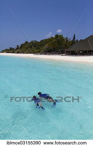 Stock Image - "Snorkelers off an island in the Maldives, Indian Ocean, Male, North Male Atoll, Maldives, Asia". Fotosearch
