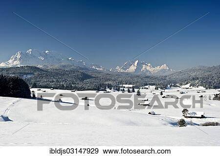 "Snow-covered pastures and hay barns, Zugspitze massif at back, Mittenwald, Upper Bavaria, Bavaria, Germany, Europe" View Large Photo Image Stock Photo - "Snow-covered pastures and hay barns, Zugspitze massif at back, Mittenwald, Upper Bavaria, Bavaria, Germany, Europe". Fotosearch