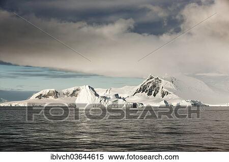 Stock Photography - "Snow-covered rocks, first morning light, Wolkenstimmung, Antarctic Peninsula, Antarctica". Fotosearch