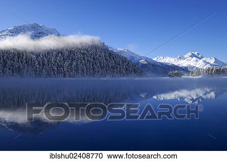 "Snowy Piz da la Margna mountain being reflected in lake Champferersee, St. Moritz, Engadin, canton of Grisons, Switzerland, Europe" View Large Photo Image Stock Image - "Snowy Piz da la Margna mountain being reflected in lake Champferersee, St. Moritz, Engadin, canton of Grisons, Switzerland, Europe". Fotosearch