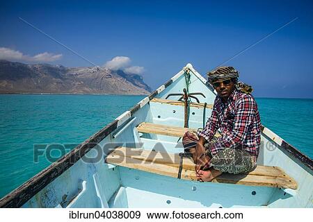"Socotran man sitting in fishing boat, Qalansia, island of Socotra, Yemen, Asia" View Large Photo Image Stock Photo - "Socotran man sitting in fishing boat, Qalansia, island of Socotra, Yemen, Asia". Fotosearch