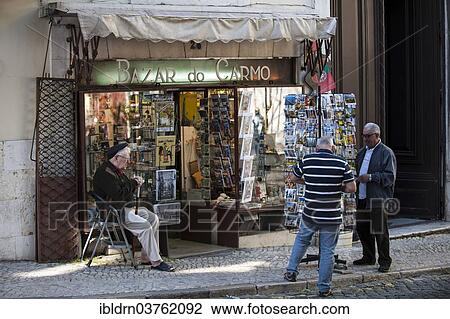 "Souvenir vendor outside his shop with customers on the Largo do Carmo square, historic center, Lisbon, Lisbon District, Portugal, Europe" View Large Photo Image Stock Image - "Souvenir vendor outside his shop with customers on the Largo do Carmo square, historic center, Lisbon, Lisbon District, Portugal, Europe". Fotosearch