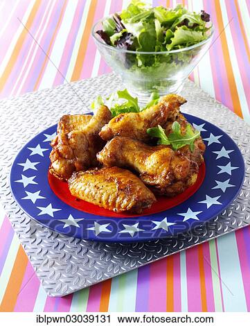 Stock Image - Spicy BBQ chicken wings and chicken drumsticks. Fotosearch