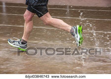 "Sports field in the rain, man running through puddles of water, Germany, Europe" View Large Photo Image Stock Image - "Sports field in the rain, man running through puddles of water, Germany, Europe". Fotosearch