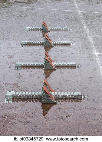 "Sports field in the rain, starting blocks, Germany, Europe" View Large Photo Image Stock Photo - "Sports field in the rain, starting blocks, Germany, Europe". Fotosearch