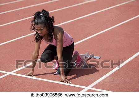 "Sporty young woman in starting position on starting blocks, running track" View Large Photo Image Stock Photograph - "Sporty young woman in starting position on starting blocks, running track". Fotosearch