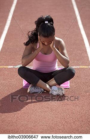 "Sporty young woman, meditating, sitting on race track, getting mentally ready" View Large Photo Image Stock Photo - "Sporty young woman, meditating, sitting on race track, getting mentally ready". Fotosearch