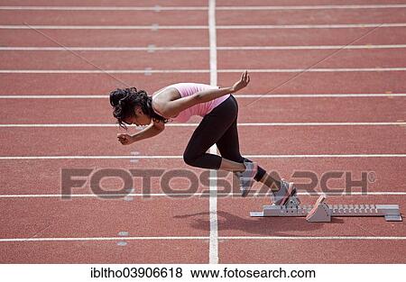 Sporty young woman starting from starting block to run on running track View Large Photo Image Stock Photo - Sporty young woman starting from starting block to run on running track. Fotosearch