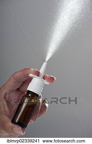 Stock Image - Spray from a nasal spray in a brown glass bottle. Fotosearch