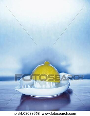 Stock Photo - Squeezed lemon in a lemon squeezer. Fotosearch