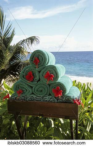 "Stack of rolled towels with red flower on the beach, Mahe, Seychelles, Africa" View Large Photo Image Stock Image - "Stack of rolled towels with red flower on the beach, Mahe, Seychelles, Africa". Fotosearch