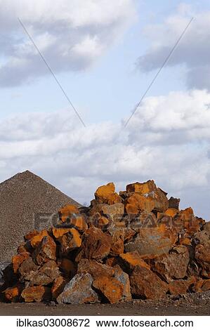 Stock Image - "Stack of rusty ferruginous rocks waiting to be recycled, Krefeld, North Rhine-Westphalia, Germany, Europe". Fotosearch