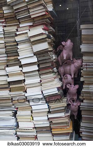Stock Photo - "Stacked books and decorative pigs in a shop window, quirky bookstore, historic shopping arcade, Passage Jouffroy, Grands Boulevards, 2nd Arrondissement, Paris, Ile-de-France, France, Europe". Fotosearch