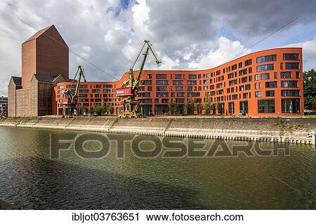 "State Archives of North Rhine-Westphalia, converted archive tower in the former RWSG storage building, next to the wave-shaped new building, Innenhafen, Duisburg, Ruhr district, North Rhine-Westphalia, Germany, Europe" View Large Photo Image Stock Image - "State Archives of North Rhine-Westphalia, converted archive tower in the former RWSG storage building, next to the wave-shaped new building, Innenhafen, Duisburg, Ruhr district, North Rhine-Westphalia, Germany, Europe". Fotosearch