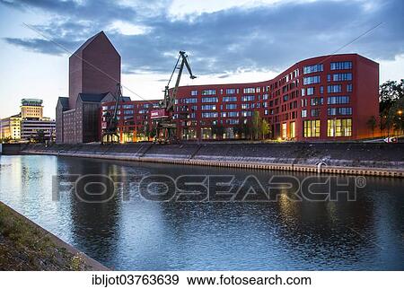 "State Archives of North Rhine-Westphalia, converted archive tower in the former RWSG storage building, next to the wave-shaped new building, Innenhafen, Duisburg, Ruhr district, North Rhine-Westphalia, Germany, Europe" View Large Photo Image Stock Photo - "State Archives of North Rhine-Westphalia, converted archive tower in the former RWSG storage building, next to the wave-shaped new building, Innenhafen, Duisburg, Ruhr district, North Rhine-Westphalia, Germany, Europe". Fotosearch