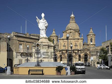Stock Photo - "Statue of St. Nicholas with the Parish Church of San Nicholas, Siggiewi, Malta, Europe". Fotosearch
