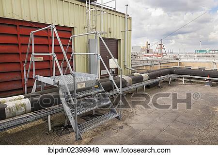 Stock Photo - "Steps giving access over roof top industrial plant pipework, Southampton, Hampshire, England, United Kingdom, Europe". Fotosearch