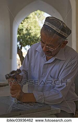Stock Image - "Stonemason chiselling a grave stone, Shakhrisabz, Shar-e Sabz or Shahrisabz, Uzbekistan, Asia". Fotosearch