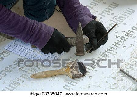 Stock Photo - "Stonemason chiselling Khmer characters into a gravestone in a stone cutting factory, Pursat, Pursat Province, Cambodia, Asia". Fotosearch