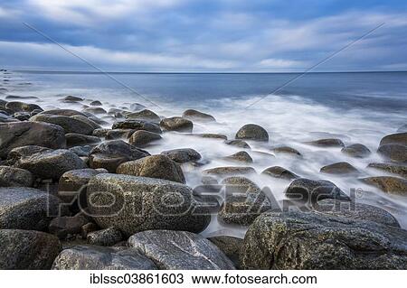 Stock Image - "Stones and waves on the coast, near Unstad, Vestvagoy, Lofoten, Norway, Europe". Fotosearch