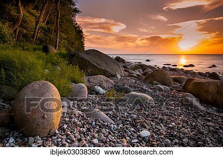 Stock Image - "Stony beach with boulders at sunset, bei Nardewitz, Rugen island, Rugen, Mecklenburg-Western Pomerania, Germany, Europe". Fotosearch
