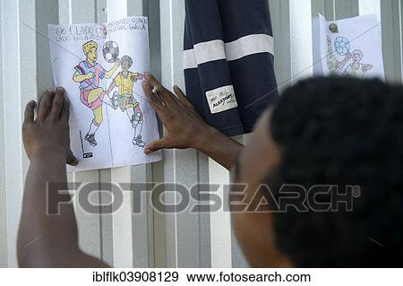 "Street child, adolescent, attaching a self-painted picture of football players on a fence, supported by social workers, Central do Brasil railway station, Rio de Janeiro, Rio de Janeiro State, Brazil, South America" View Large Photo Image Stock Photo - "Street child, adolescent, attaching a self-painted picture of football players on a fence, supported by social workers, Central do Brasil railway station, Rio de Janeiro, Rio de Janeiro State, Brazil, South America". Fotosearch