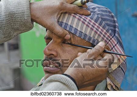"Street eye cleaner with a customer in the streets of Kolkata, India, Asia" View Large Photo Image Stock Photo - "Street eye cleaner with a customer in the streets of Kolkata, India, Asia". Fotosearch