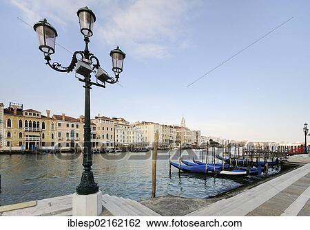 Stock Image - "Street light, view from Campo della Salute of gondolas, Grand Canal, Canal Grande near the Church of Santa Maria della Salute, Venice, Venezia, Veneto, Italy, Europe". Fotosearch
