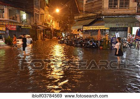 Stock Photo - "Street scene with a flooded road during heavy monsoon rain at night, city centre, Phnom Penh, Cambodia, Asia". Fotosearch