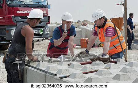 "Structural engineers placing the first blocks during a building site load test, at a construction site in Fridolfing, Bavaria, Germany, Europe" View Large Photo Image Stock Photography - "Structural engineers placing the first blocks during a building site load test, at a construction site in Fridolfing, Bavaria, Germany, Europe". Fotosearch