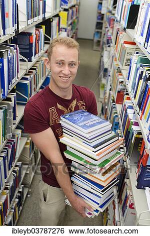 "Student carrying a stack of books in the Departmental Library of the University of Hohenheim, Stuttgart, Baden-Wurttemberg, Germany, Europe" View Large Photo Image Stock Photograph - "Student carrying a stack of books in the Departmental Library of the University of Hohenheim, Stuttgart, Baden-Wurttemberg, Germany, Europe". Fotosearch
