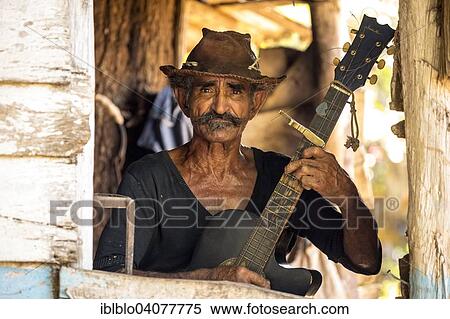 Stock Photography - "Sugar cane farmer playing the guitar, Valle de los Ingenios, Trinidad, Sancti Spiritus Province, Cuba, North America". Fotosearch