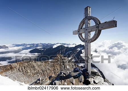 Stock Photograph - Summit cross on Seelenkogel mountain, the Gurgler valley below, province of Bolzano-Bozen, Italy, Europe. Fotosearch