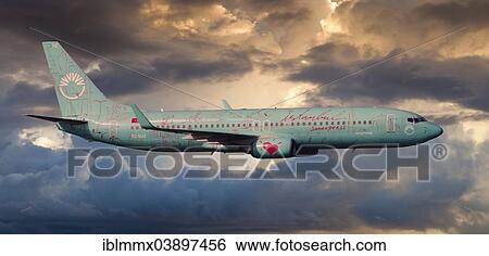 Stock Photograph - SunExpress Boeing 737 in flight in the evening light. Fotosearch
