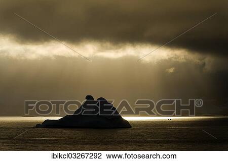 "Sunlight shining through a hole in the clouds, silhouette of an iceberg at the front, Errera Channel, Arctowski Peninsula, Antarctic Peninsula, Antarctica" View Large Photo Image Stock Image - "Sunlight shining through a hole in the clouds, silhouette of an iceberg at the front, Errera Channel, Arctowski Peninsula, Antarctic Peninsula, Antarctica". Fotosearch